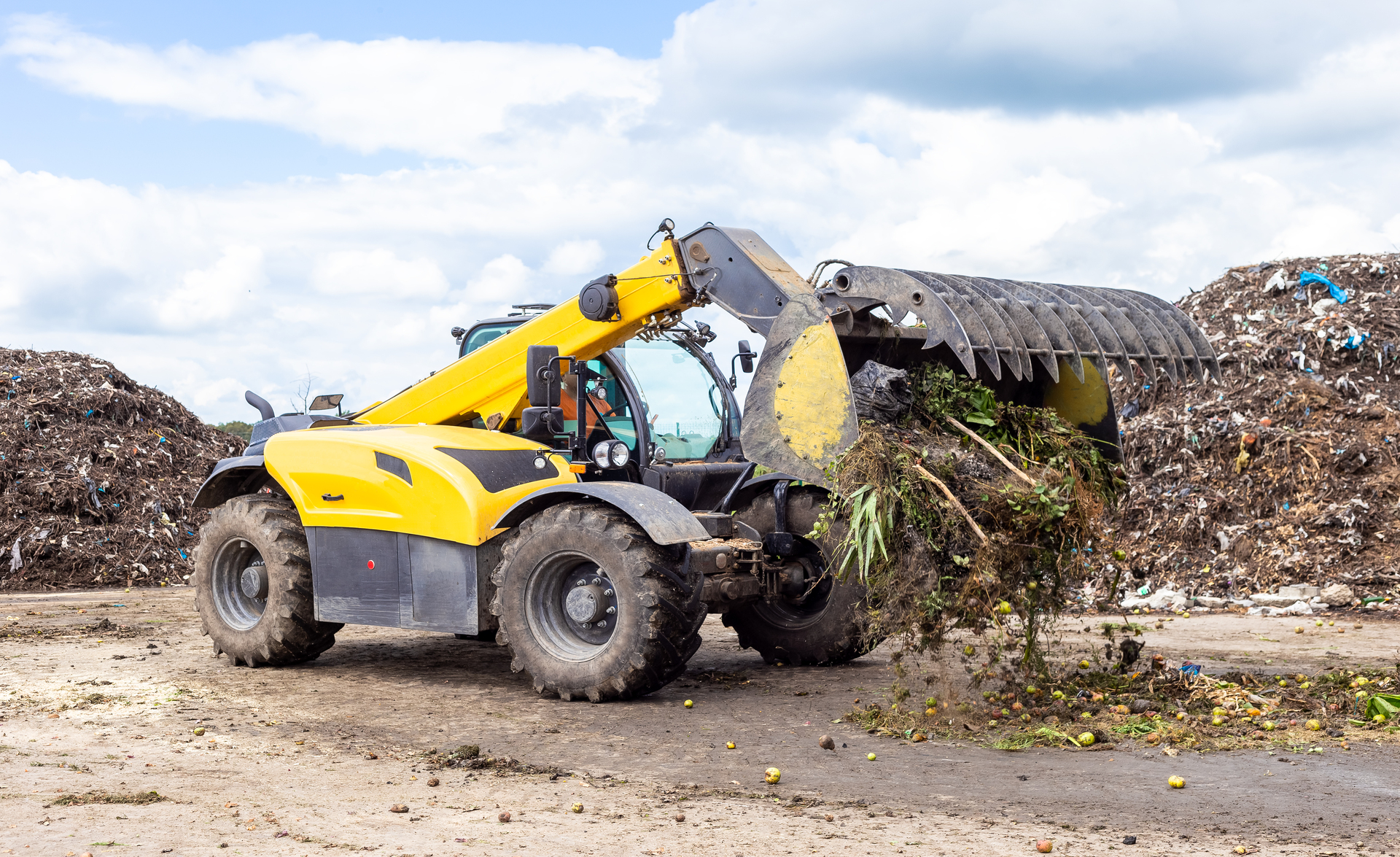 Stor gul maskin arbetar med kompostmaterial