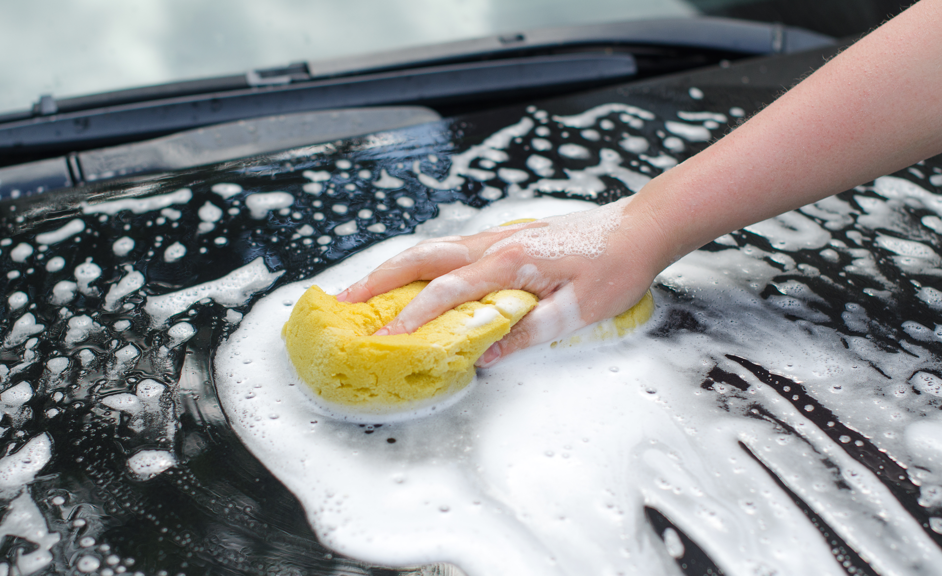 En person som tvättar bilen med svamp