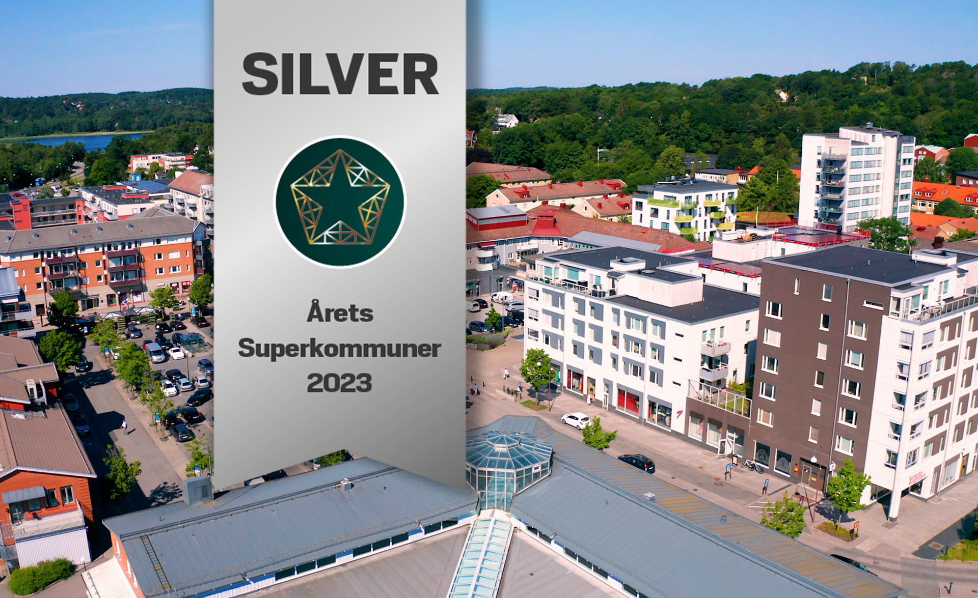 Flygfoto på Mölnlycke centrum och en dekal med texten: Silver årets superkommuner 2023