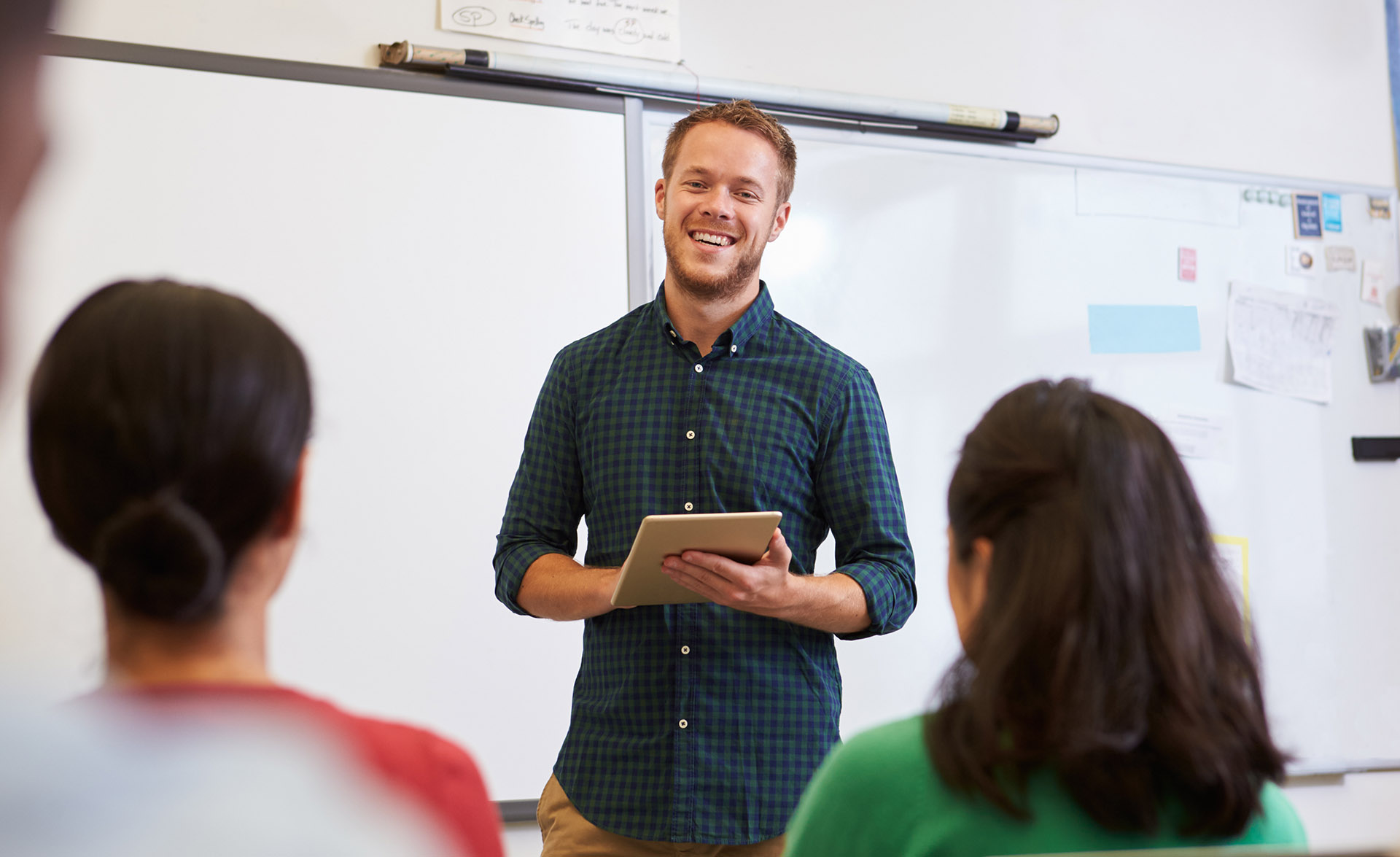 En manlig lärare undervisar vuxna i ett klassrum.