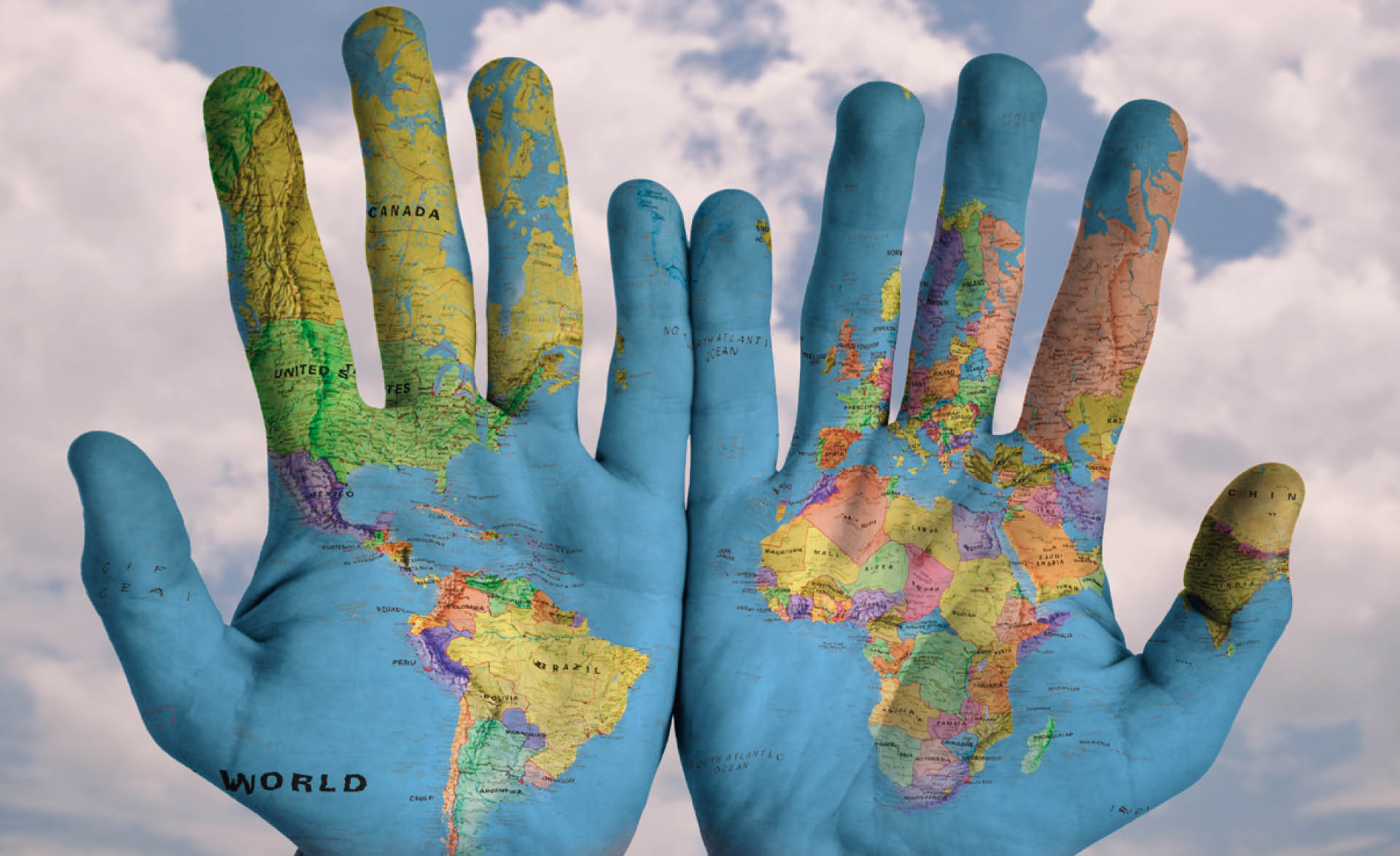 Två händer med en världskarta målad på handflatorna.