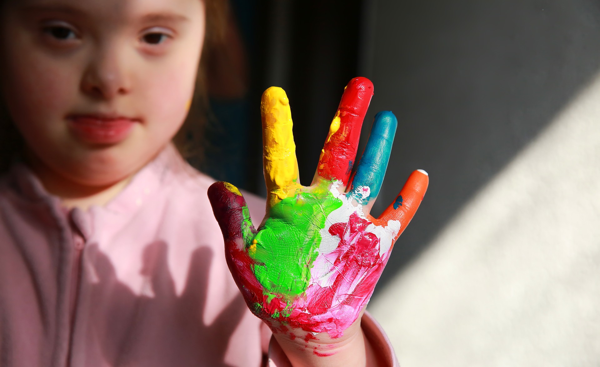 Flicka med downs syndrom med målad hand. Foto: DenysKuvaiev/Mostphotos 